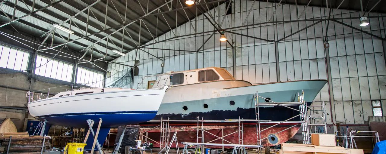Embarcaciones en proceso de reparación y reacondicionamiento dentro de un hangar
